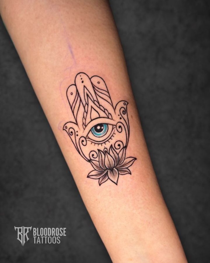 Hamsa hand tattoo with evil eye and lotus