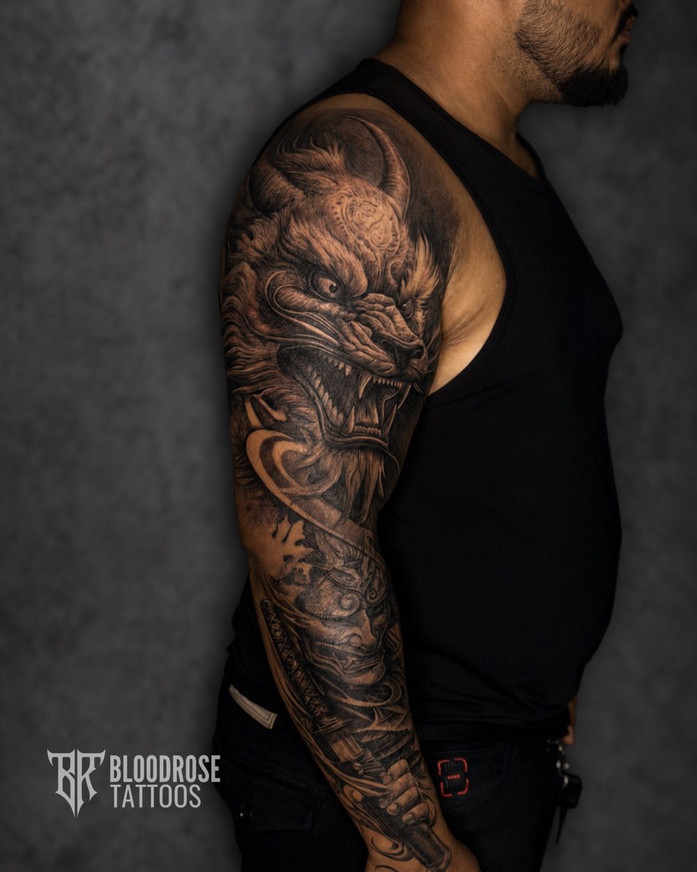 Black and grey full sleeve with a dragon on the upper arm and an oni mask and katana on the forearm